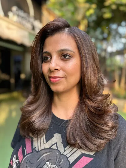 A stunning transformation from natural black hair to a vibrant, warm brown. The new color completely changes her look while enhancing her features.