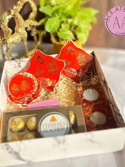 A stunning red and gold Diwali hamper, containing all the essentials for your festive decor.