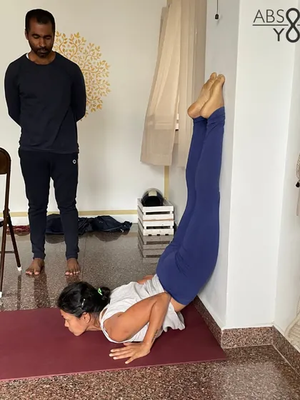 Progress is a result of consistent practice. Years ago, I struggled with a hunched back and limited shoulder strength. Today, with the guidance of my teacher, I can attempt a wall-supported Shalabhasana. All it takes is showing up.