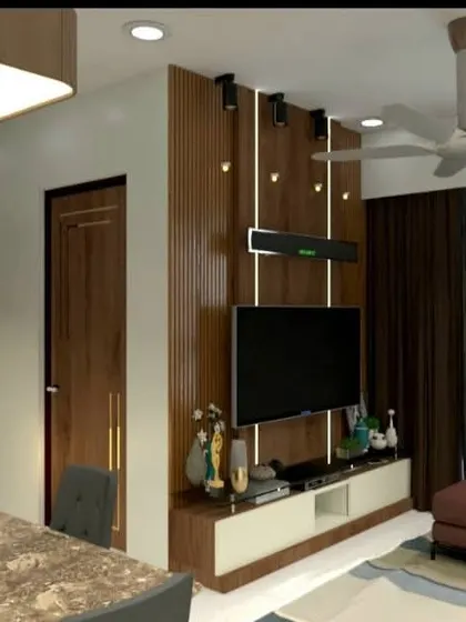 A modern living room design featuring a wood-panelled TV wall with a soundbar, a plush leatherette sofa, and a marble-top dining table. The use of a large mirror with a geometric pattern adds depth and a touch of glamour to the space.