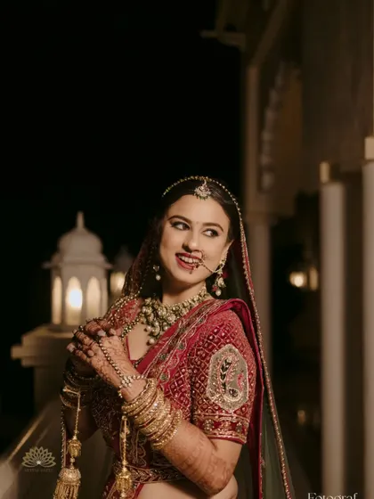 A candid shot of the bride, her smile as bright as her jewelry. Her mehndi-adorned hands add a touch of traditional elegance to the moment.