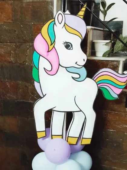 A unicorn character cutout placed on a purple and white balloon pillar. These are versatile decorations that can be placed anywhere in the party area.