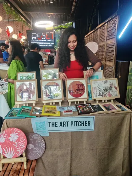A candid photo of me at my art market stall. These events are a wonderful opportunity to interact with customers and share the stories behind my paintings.