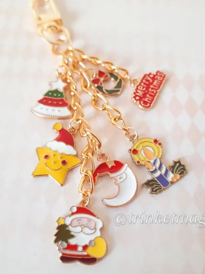 A close-up of the Christmas charm keychain, showing the detail on each little enamel charm, from Santa to the "Merry Christmas" sign.