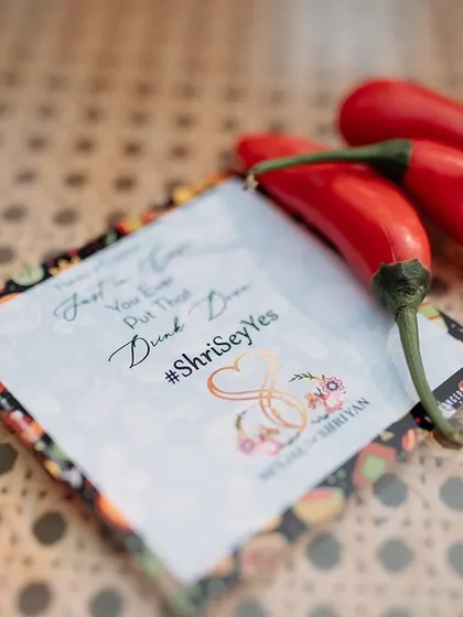 A fun and spicy detail: a custom-printed card for a party game, placed next to bright red chillies.