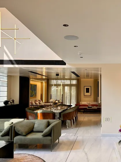 A view from the living area looking towards the dining space in the Palm Springs Villa. The open-plan layout and consistent material palette create a seamless flow between different functional zones.