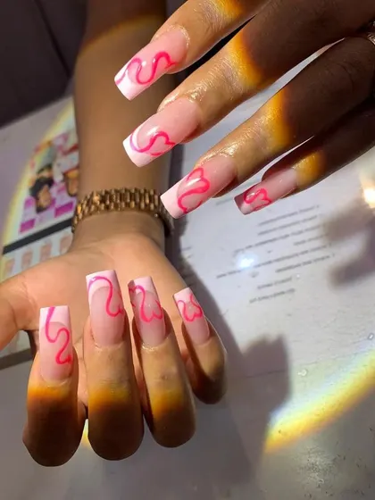 Learn to create abstract and trendy designs like these pink swirls on a long, clear extension base. This style is very popular and shows a high level of artistic control.