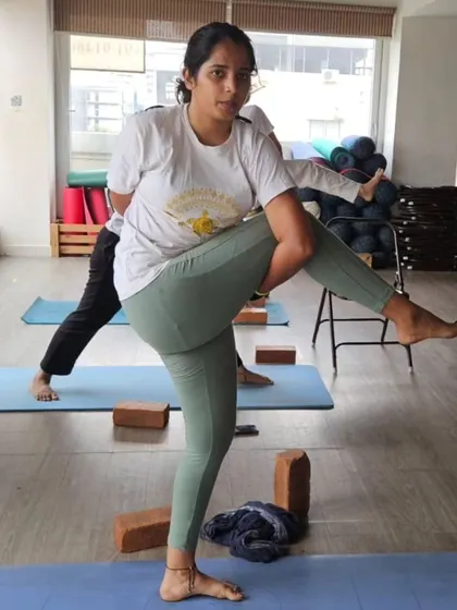 A student practices a bound standing twist, showcasing the balance and core strength developed through our comprehensive TTC curriculum.