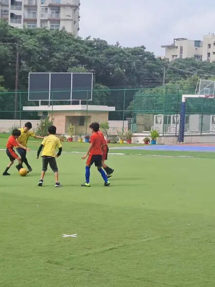 An action shot from the boys' Inter-House Football Tournament, with players from opposing houses vying for the ball. The fast-paced game showcases the students' agility and strategic thinking.