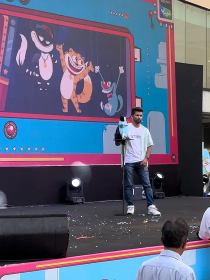 Performing with my parrot puppet at the Sony Yay event, which featured characters like Oggy and the Cockroaches in the background.