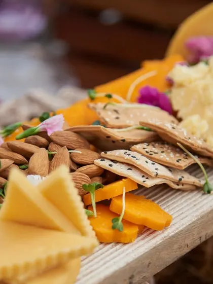Another angle of a classic cheeseboard, showcasing a variety of hard and soft cheeses alongside fresh almonds and crackers. A perfect start to any celebration.