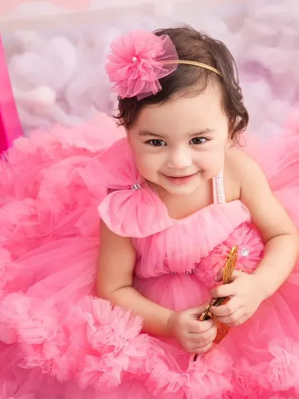 A close-up portrait of our little Barbie girl, looking absolutely precious in her fluffy pink dress during her themed birthday session.