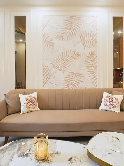 The leaf-patterned wallpaper behind the sofa serves as a beautiful and subtle feature wall, adding a touch of nature-inspired elegance to this living room.