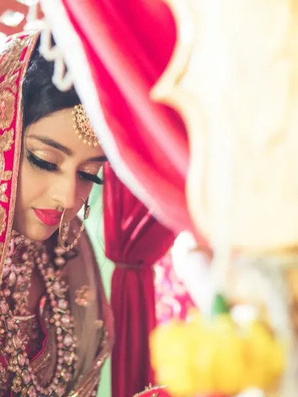 An artistic, close-up shot of a bride during her ceremony. The framing creates a sense of intimacy and focuses on her serene expression.