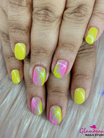 A fun and summery design with a mix of solid yellow nails and accent nails featuring abstract swirls of pink and yellow.