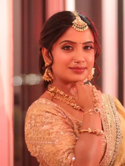A thoughtful pose, showing the beautiful details of her makeup and jewelry. The soft lighting enhances her bridal glow.