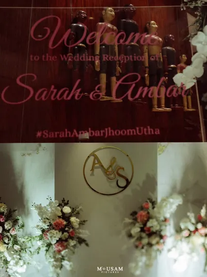 Details from a wedding reception, including the welcome sign with the couple's hashtag and the elegant floral decor with their monogram. These elements add a personal touch to the celebration.