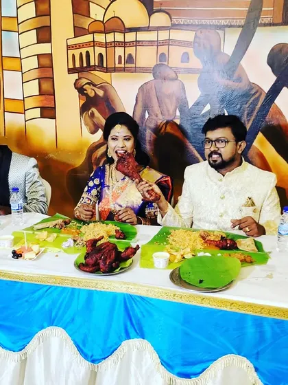 A couple enjoying their meal against a backdrop of traditional art.