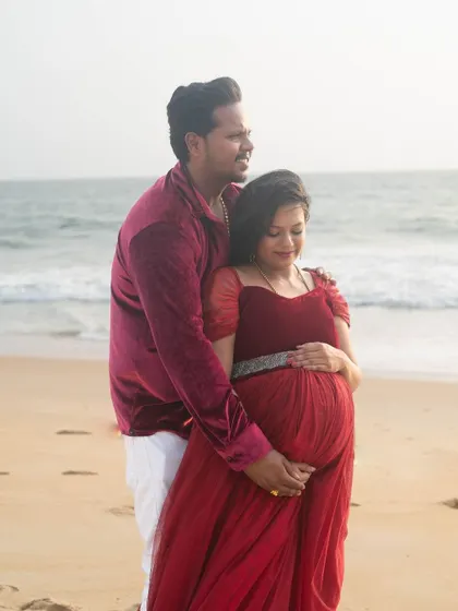 A romantic beach maternity shoot. We have matching outfits for couples, like this red gown and velvet shirt combination.