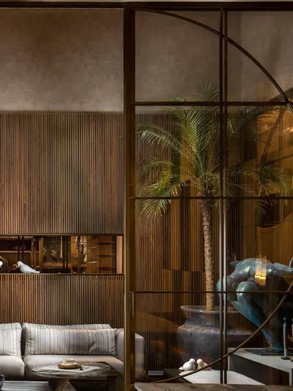 This custom millwork design features a muted and earthy color palette. The vertically grooved wood paneling includes an inset display niche, demonstrating our focus on choosing the right materials and details for a space.
