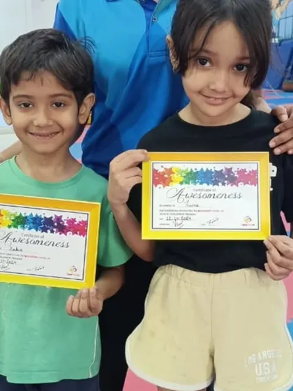 Two happy students show off their "Awesomeness" certificates.