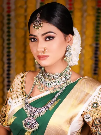 A closer look at the reception makeup and jewelry. The detailed eye makeup and perfectly matched lip color enhance the bride's features, while the layered necklaces add to the grandeur of the look.