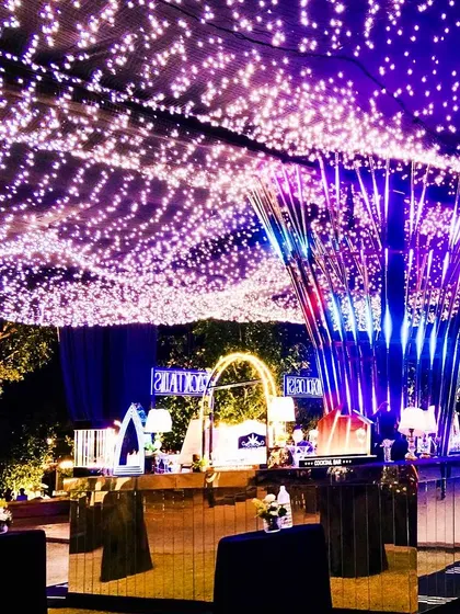 For this outdoor sangeet, I created a canopy of thousands of fairy lights and a futuristic, mirrored bar to set a high-energy, glamorous tone for a night of dancing.