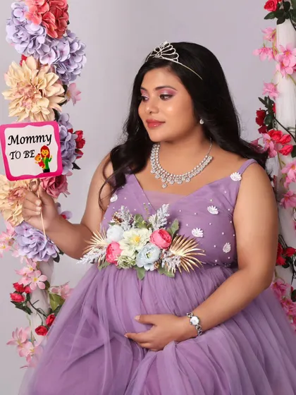 A playful and sweet shot with a "Mommy to be" prop, highlighting the joy and excitement of this special time. The floral swing makes the perfect backdrop.