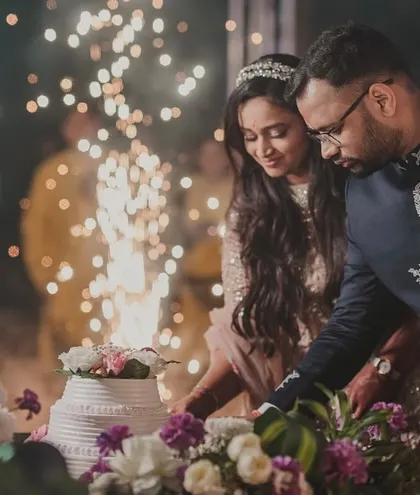 Even the cake cutting can be a spectacle. A simple sparkler adds a touch of magic to this sweet moment, with the floral-adorned cake table completing the scene.