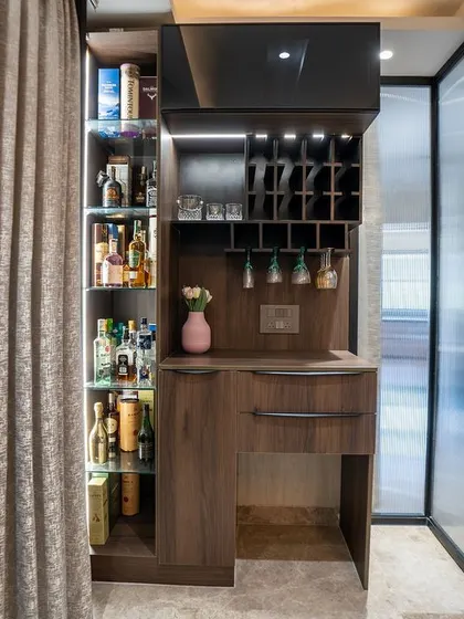 A discreet and stylish bar unit tucked away in the corner of the living room. The dark wood finish and built-in wine rack make it a functional and elegant addition to the space.