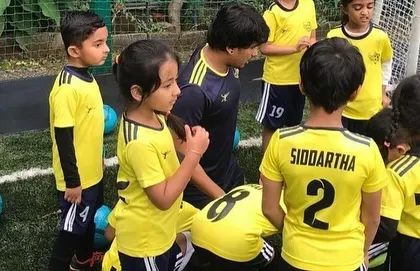 A coach gathers the little ones for instructions. Clear communication and a friendly approach make it easy for our youngest players to understand and participate.