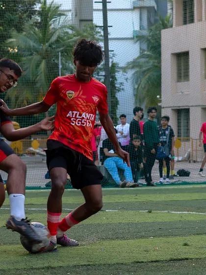 A player using his strength to hold off a defender and maintain possession of the ball.