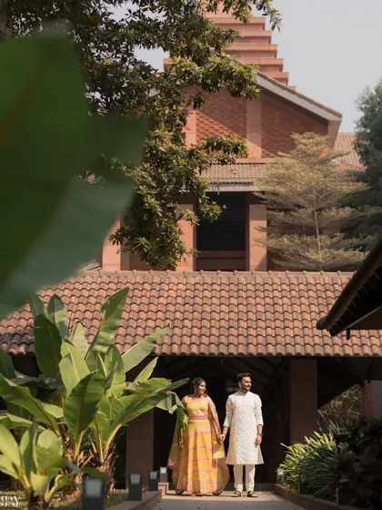 A wide-angle shot capturing the couple walking hand-in-hand against the beautiful architecture of the wedding venue.