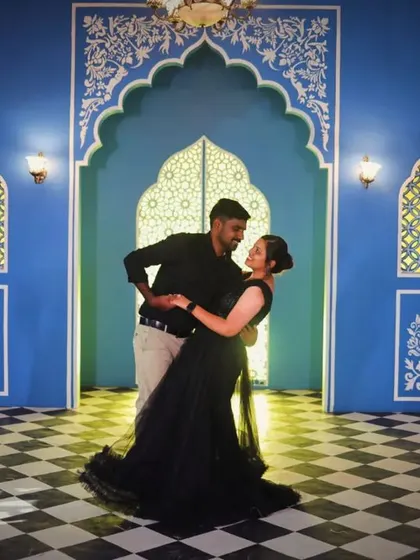A dancing pose in a stunning blue and white tiled room. Our simple black gown allows the colorful backdrop to shine.