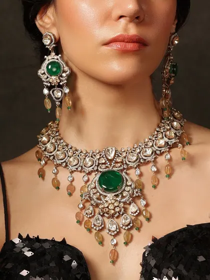 A close-up of a magnificent bridal set from the Emrosia collection, showcasing the deep green of the central emerald against the sparkle of polki diamonds.