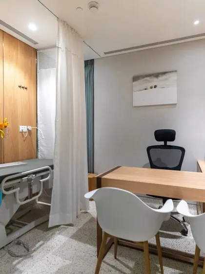 A consultation room at Breach Candy Hospital designed for comfort and professionalism. The use of wood paneling, clean lines, and ergonomic seating creates a space where patients can feel at ease while receiving care.