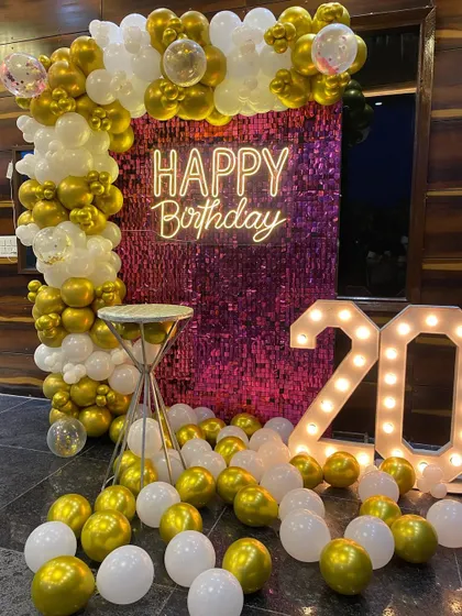 Another shot of the 20th birthday decor, highlighting the shimmer wall and the abundance of gold and white balloons.