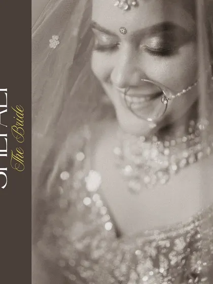 A serene black and white portrait of the bride, her gentle smile captured under the soft light of her veil. This timeless shot focuses purely on her emotion and beauty.