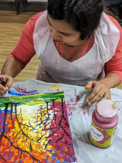 A close-up of a participant using a palette knife to create a textured tree in a canvas painting workshop. We explore various tools to help you achieve different effects.