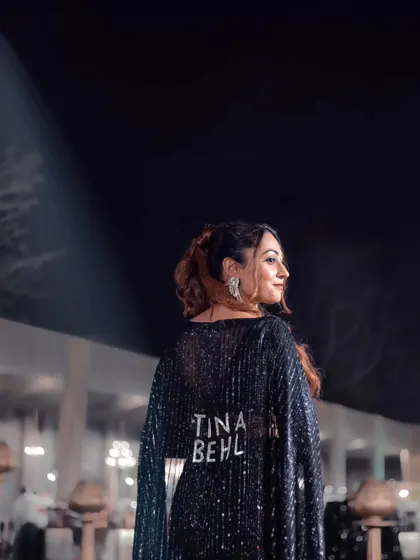 A profile shot showing off my custom "Tina Behl" cape. It's a powerful branding statement and a reflection of my confident personality.