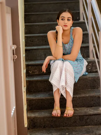 A full-length shot on the stairs, capturing a moment of quiet waiting. The composition and lighting create a very cinematic feel.