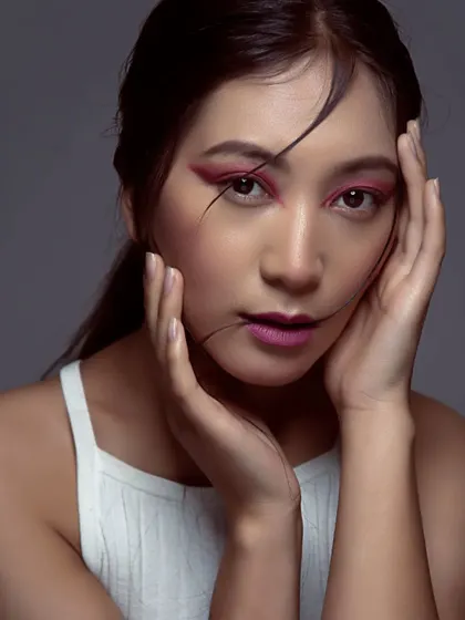 This shot captures the full effect of the graphic pink eye makeup. It's a testament to how creative makeup can transform a look for a fashion or beauty photoshoot.