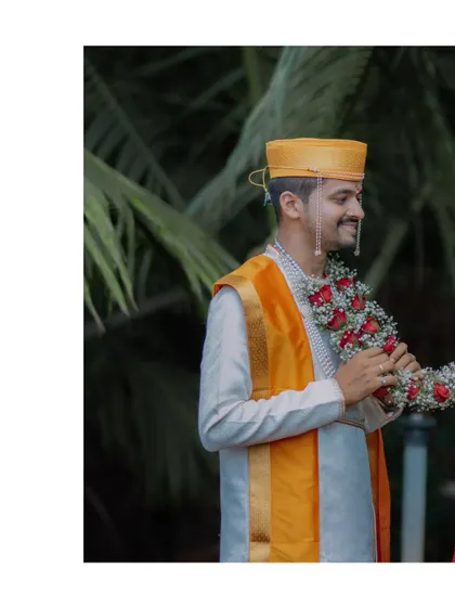 A candid portrait of the groom, smiling as he holds the 'varmala', ready for one of the most awaited wedding rituals.