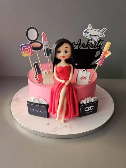 We made her again! A cake for the modern woman, featuring a figurine in a hot red dress, surrounded by her favorite things: shopping bags, makeup, and her phone.