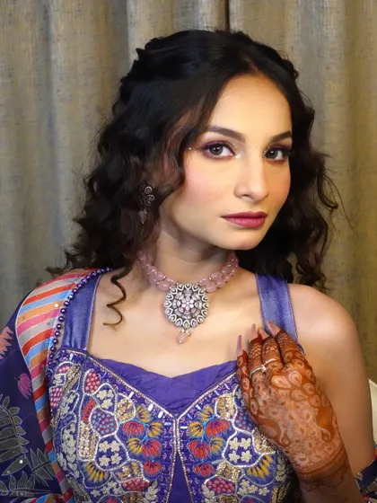 This shot showcases how the makeup, hair, and jewelry come together to create a complete and cohesive look for a bride's Mehendi ceremony.