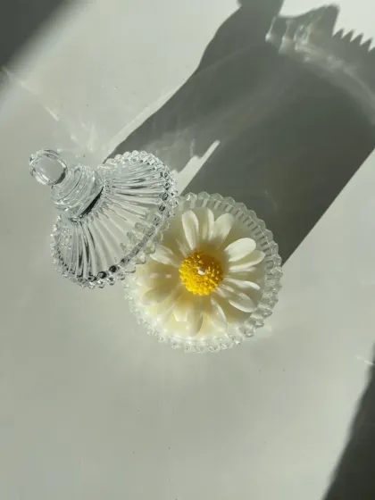 This daisy candle is hand-poured into a stunning vintage-style glass carousel jar with a lid. It's a beautiful decorative piece, even when not lit.