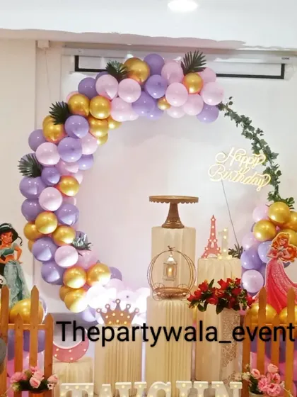 A first birthday princess theme with a beautiful purple and gold balloon arch and light-up name.