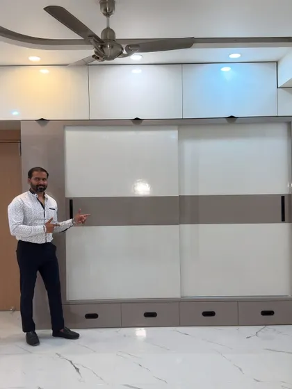 Here I am with a completed sliding wardrobe. This design features a two-tone finish with a central band, creating a modern look. The floor-to-ceiling construction with integrated lofts ensures you get the maximum possible storage from the wall space.