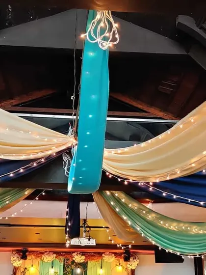 For this indoor Mehendi, we used colorful drapes in shades of blue, green, and cream, all interwoven with fairy lights. This created a festive and vibrant ceiling treatment.