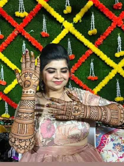 A happy client posing with her intricate Karva Chauth mehndi.